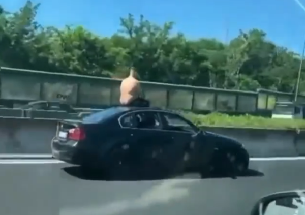 Follia sul Raccordo di Roma: guida con i piedi mentre si rinfresca seduto sul tetto della sua BMW [VIDEO]