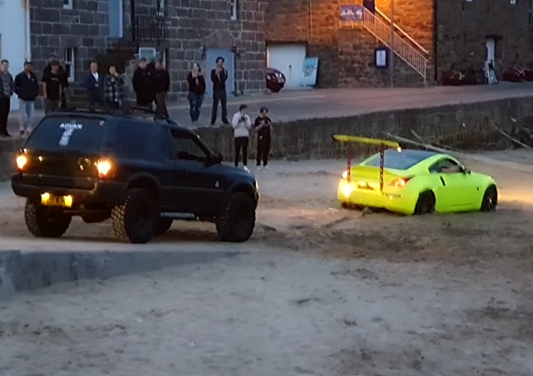 Fa il bullo con la Nissan 350Z in spiaggia, ma si pianta nella sabbia e deve chiedere aiuto a un amico con il 4x4 per farsi tirare fuori [VIDEO]