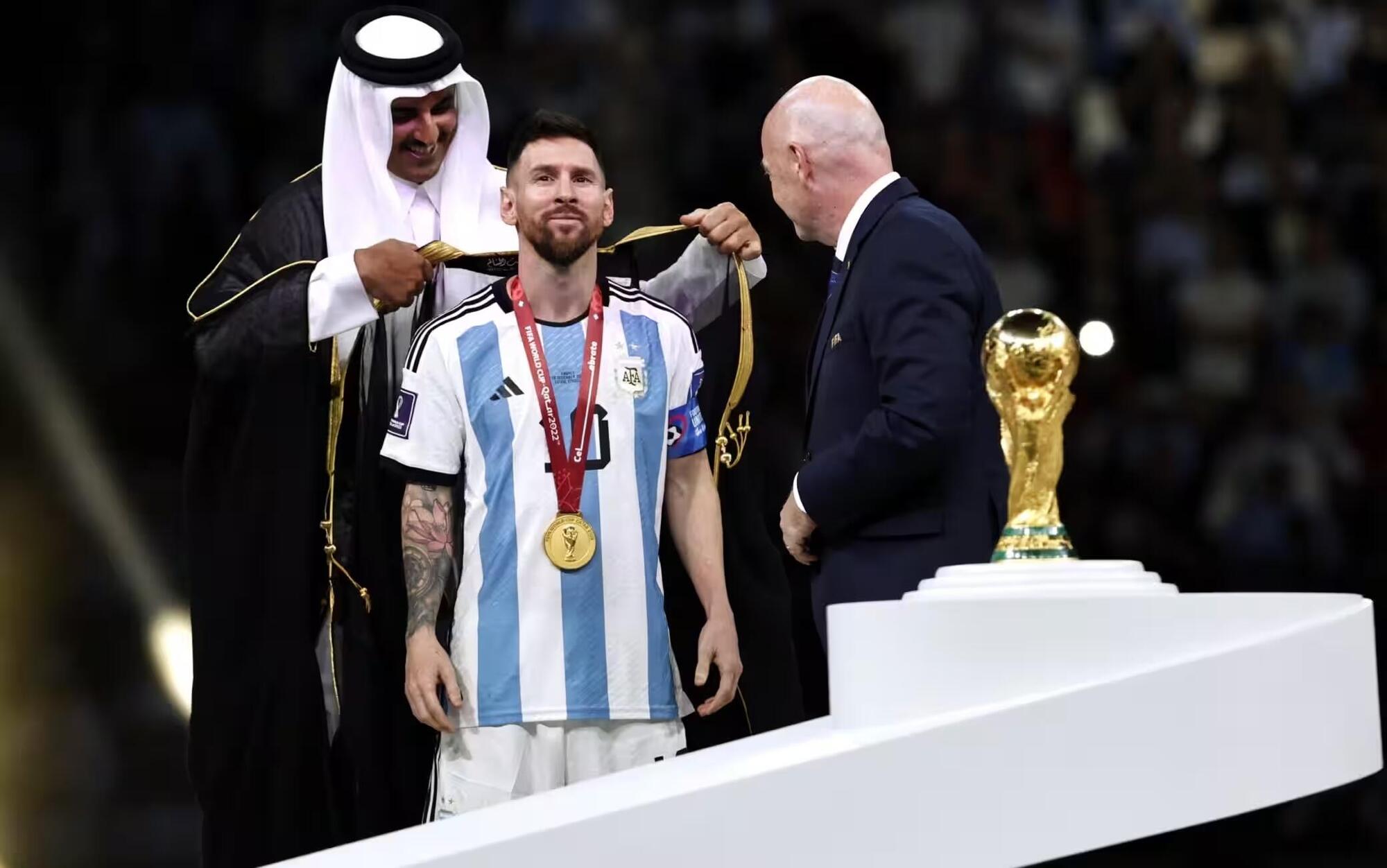 Messi che si fa mettere la tunica qatariota