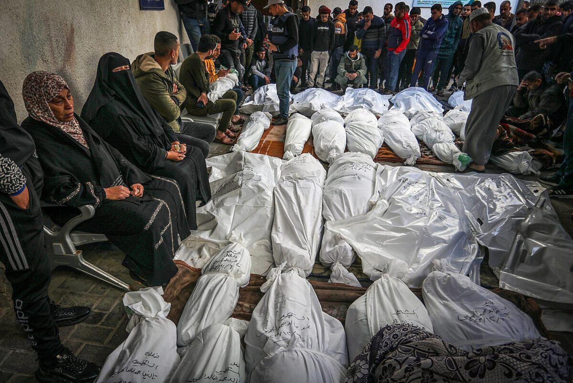 Dei palestinesi piangono i cadaveri chiusi nei sacchetti