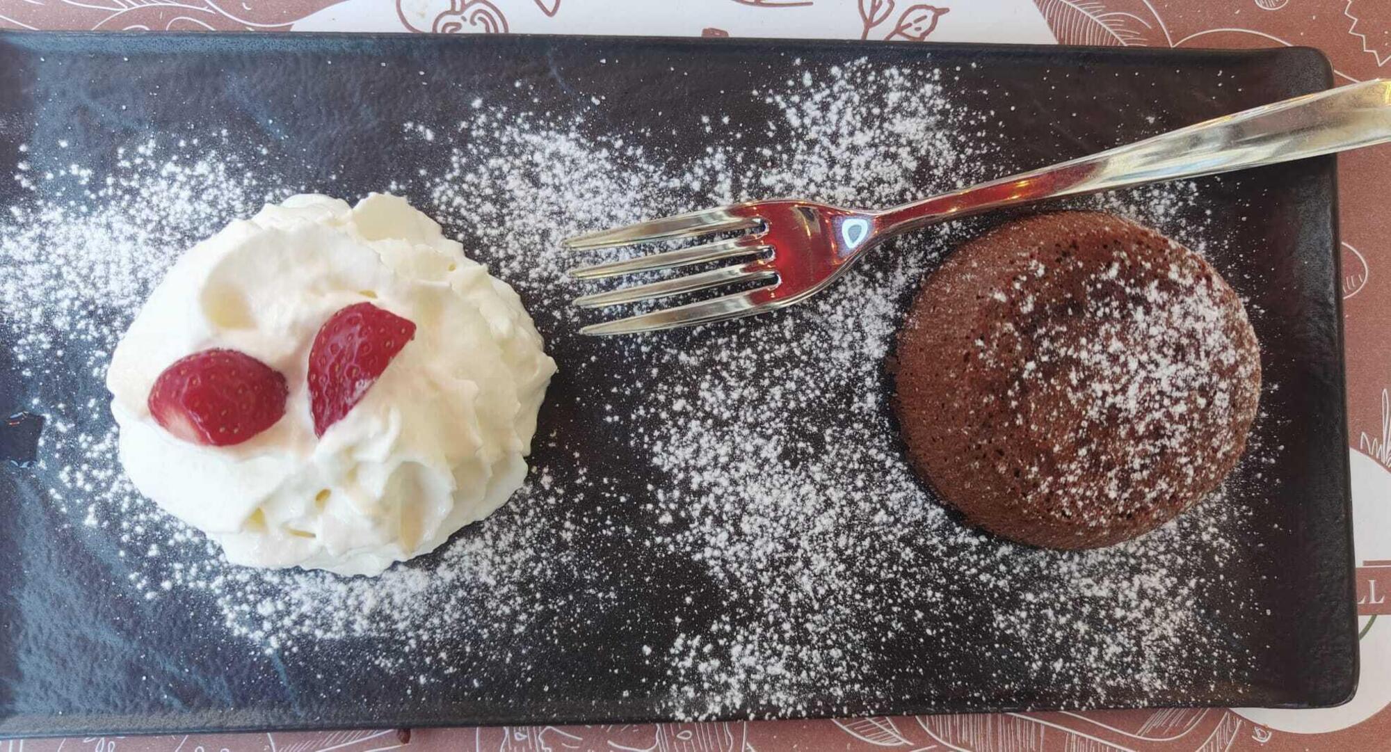 Tortino al cacao dal cuore cuore caldo con panna e fragole