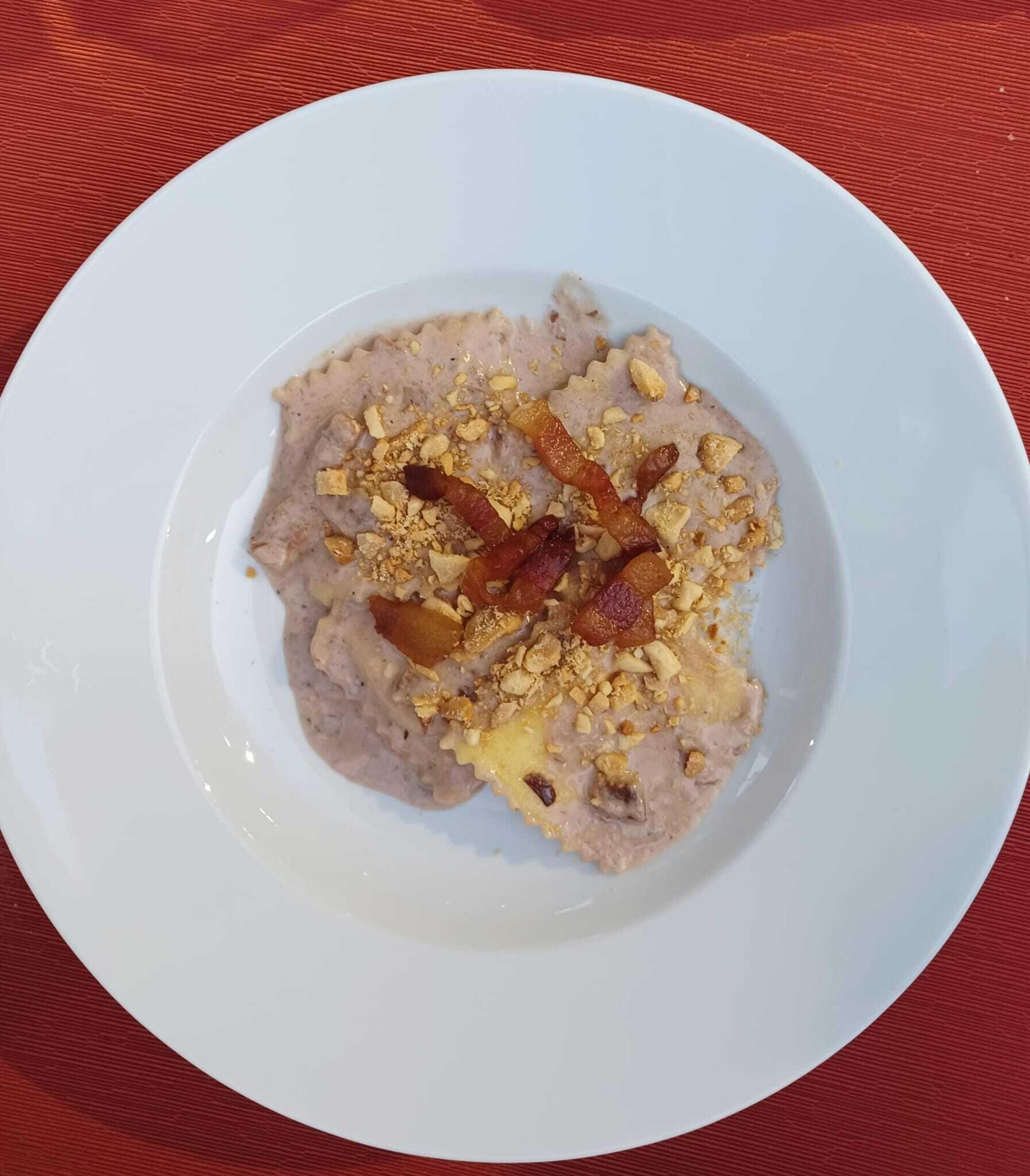 Ravioli di ricotta al radicchio con i formaggi, guanciale e mandorle tritate