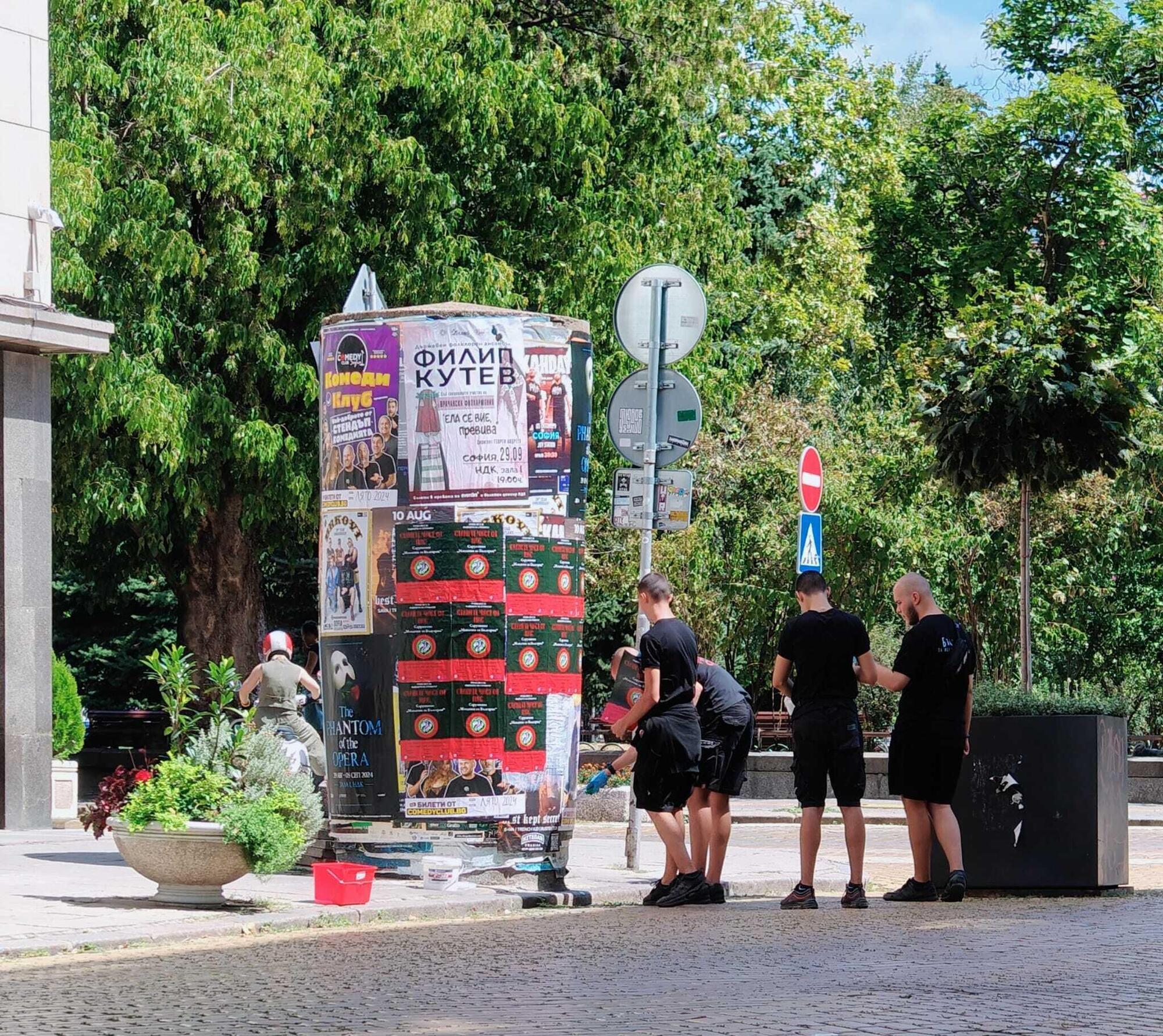 Un gruppetto di giovanissimi neonazisti che si aggira indisturbato in centro a Sofia, imbrattando con manifesti propagandistici, munito di colla. Dalla foto di spalle non si nota, ma si tratta di ragazzi giovanissimi, probabilmente minorenni