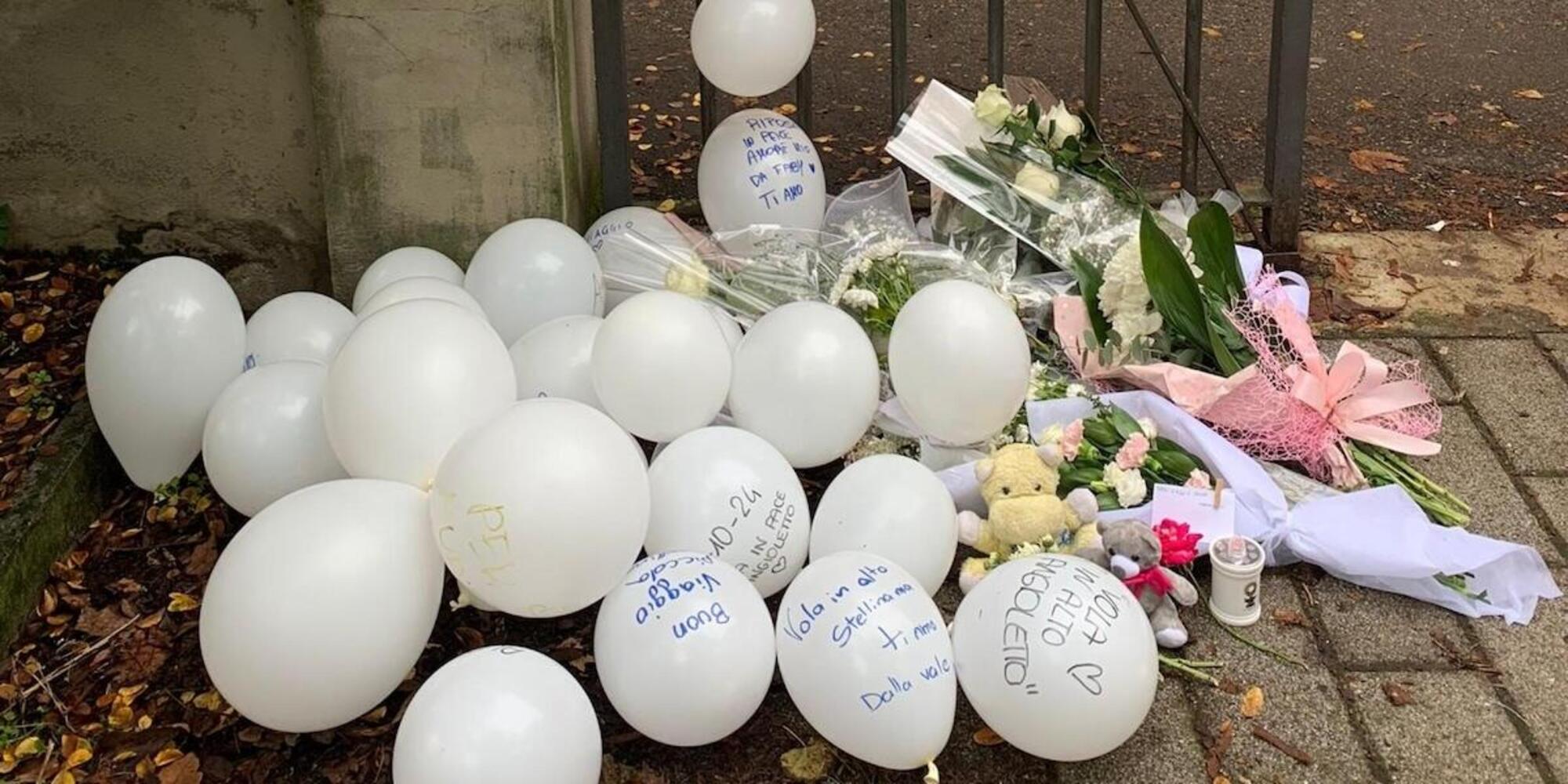 Palloncini bianchi, fiori e messaggi all'esterno del liceo Colombini di Piacenza, per commemorare Aurora Tila