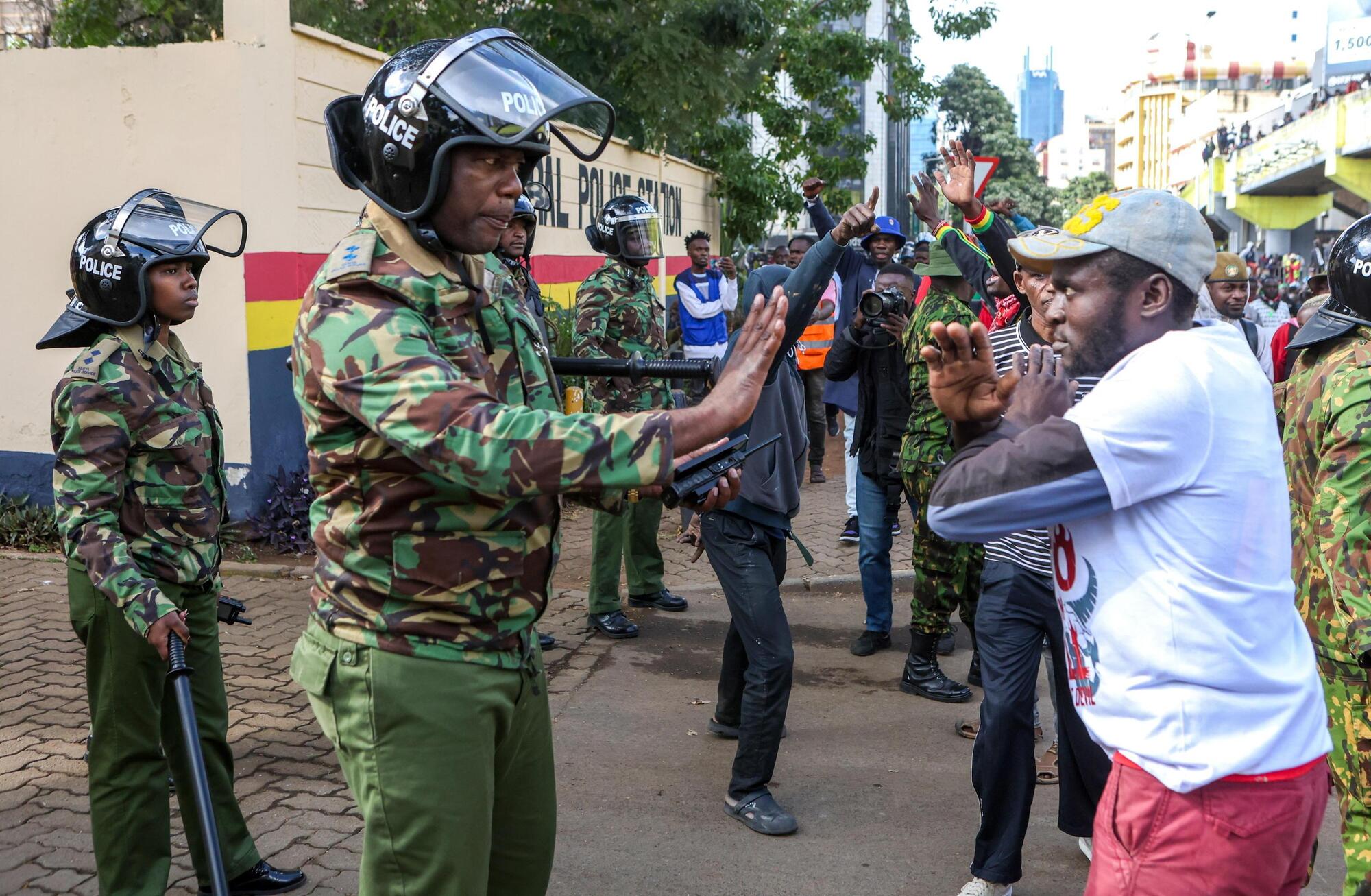 Proteste in Kenya: un manifestante fissa il poliziotto a braccia incrociate, come a dire: &quot;Non ho paura e da qui non mi muovo&quot;