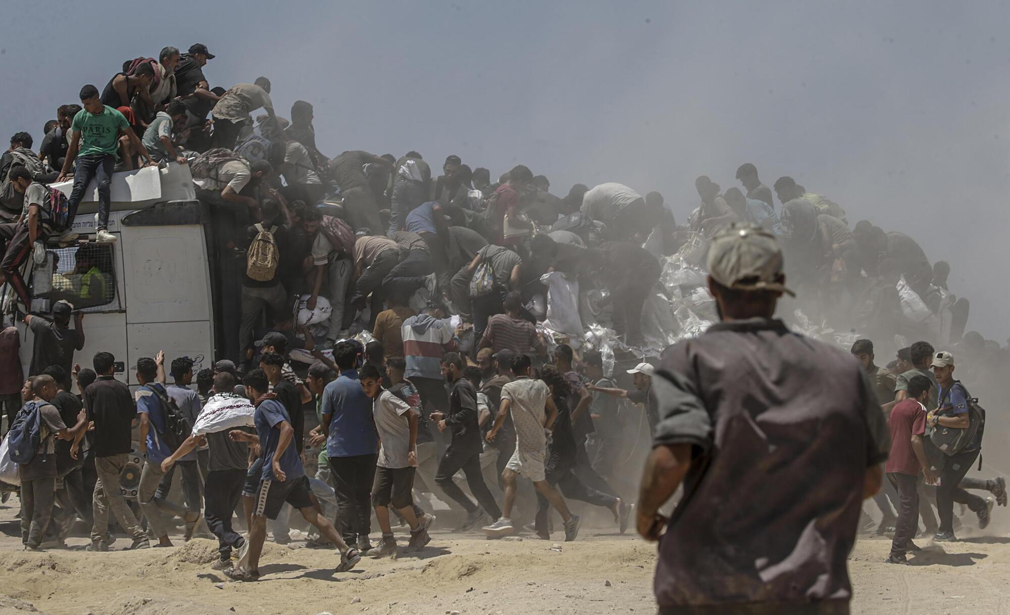 La folla a Gaza che si accalca intorno a un furgone con gli aiuti umanitari