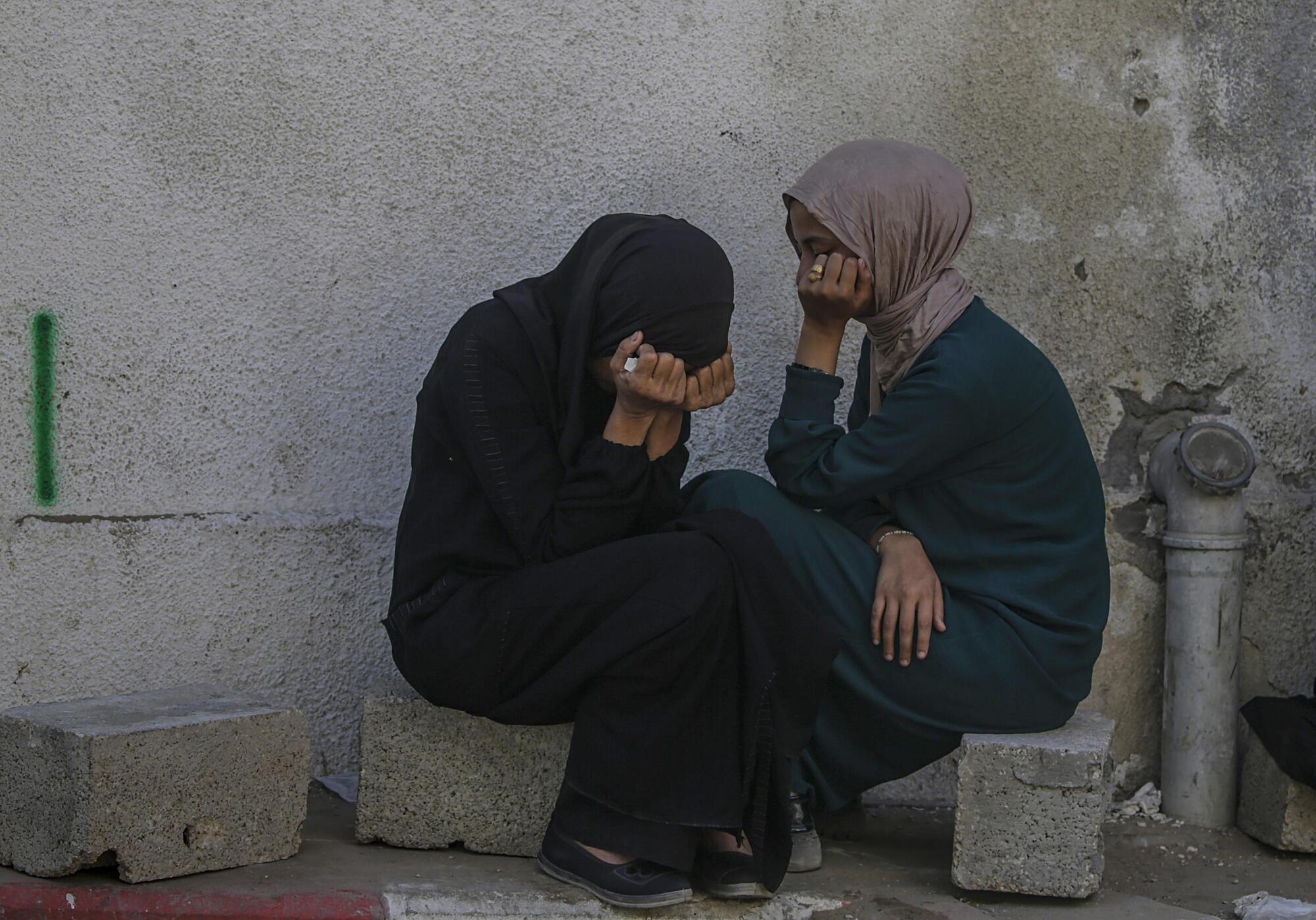 Donne palestinesi piangono i parenti morti nei bombardamnti israeliani